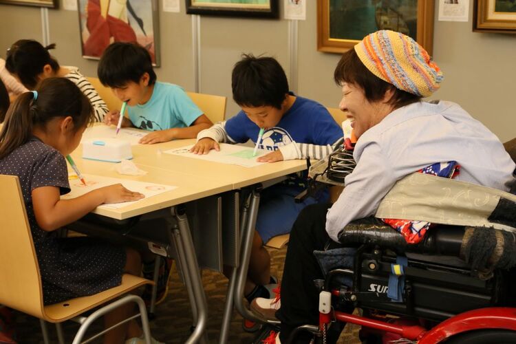 口で絵を描く体験活動に参加する児童(西宮絵画展にて)